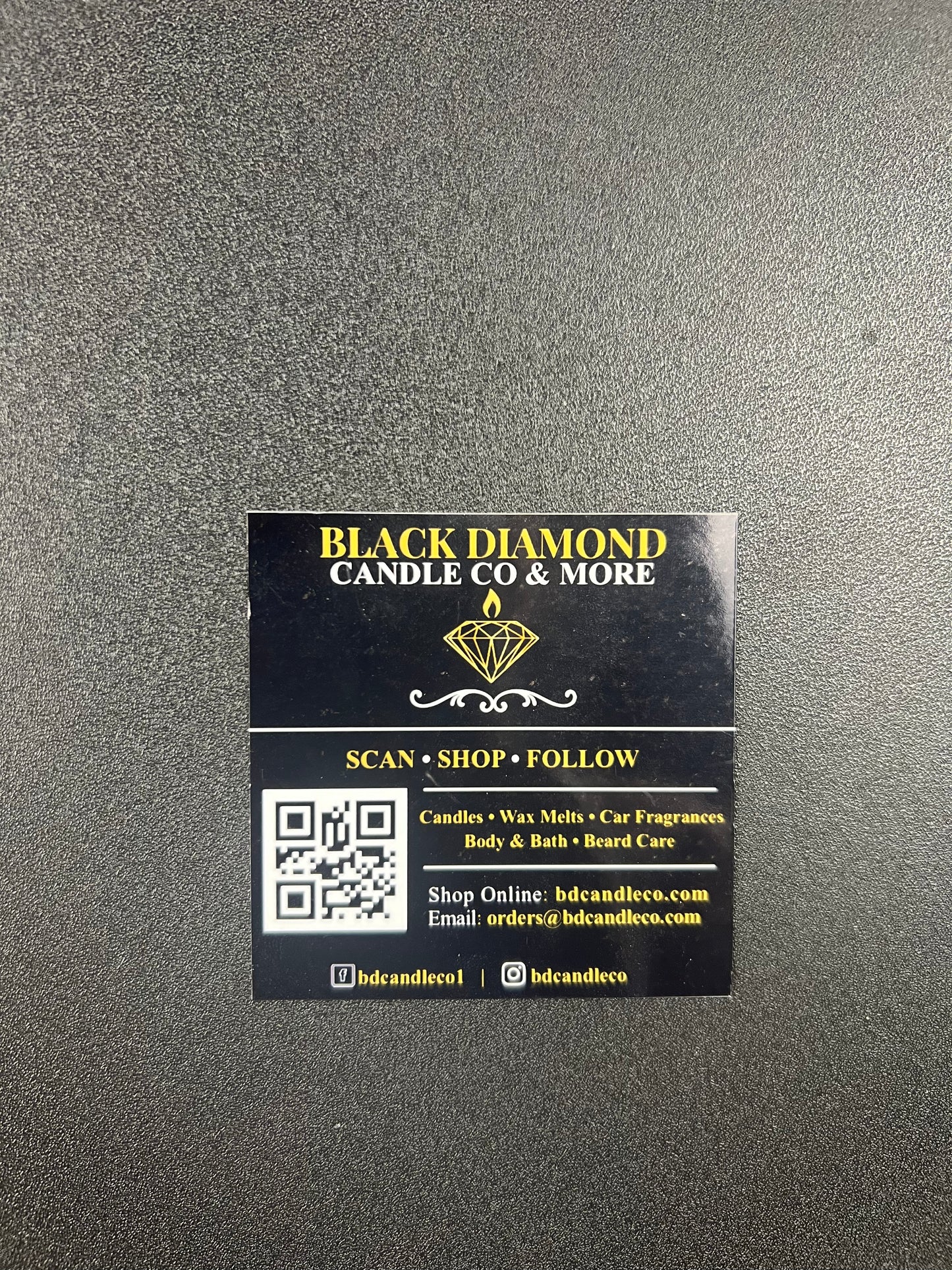Black and gold business card for Black Diamond Candle Co. on a gray background