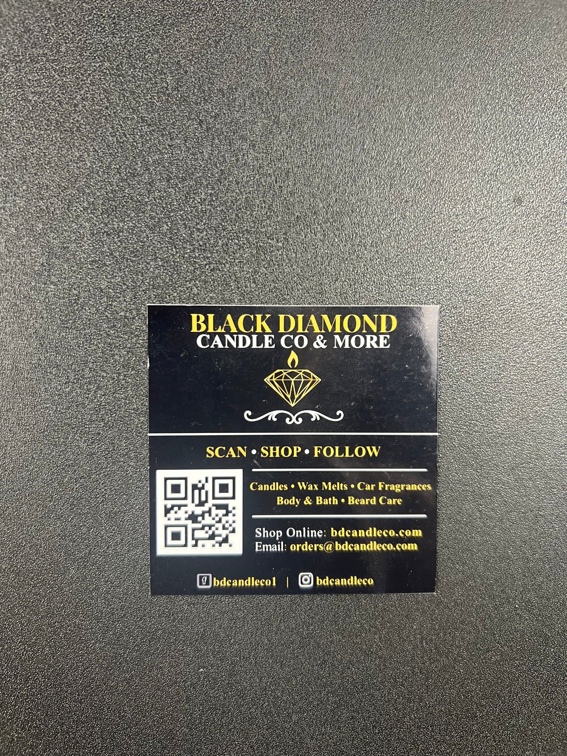 Black and gold business card for Black Diamond Candle Co. on a gray background