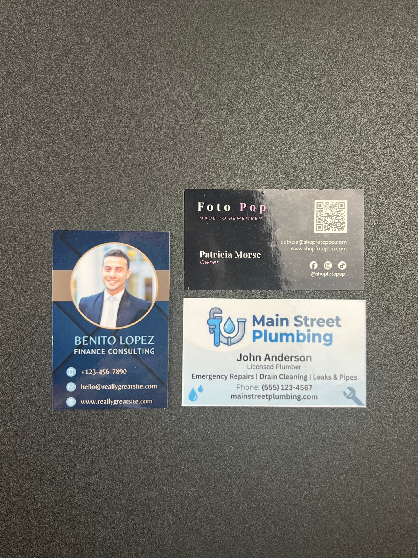 three business cards from different companies on a gray background