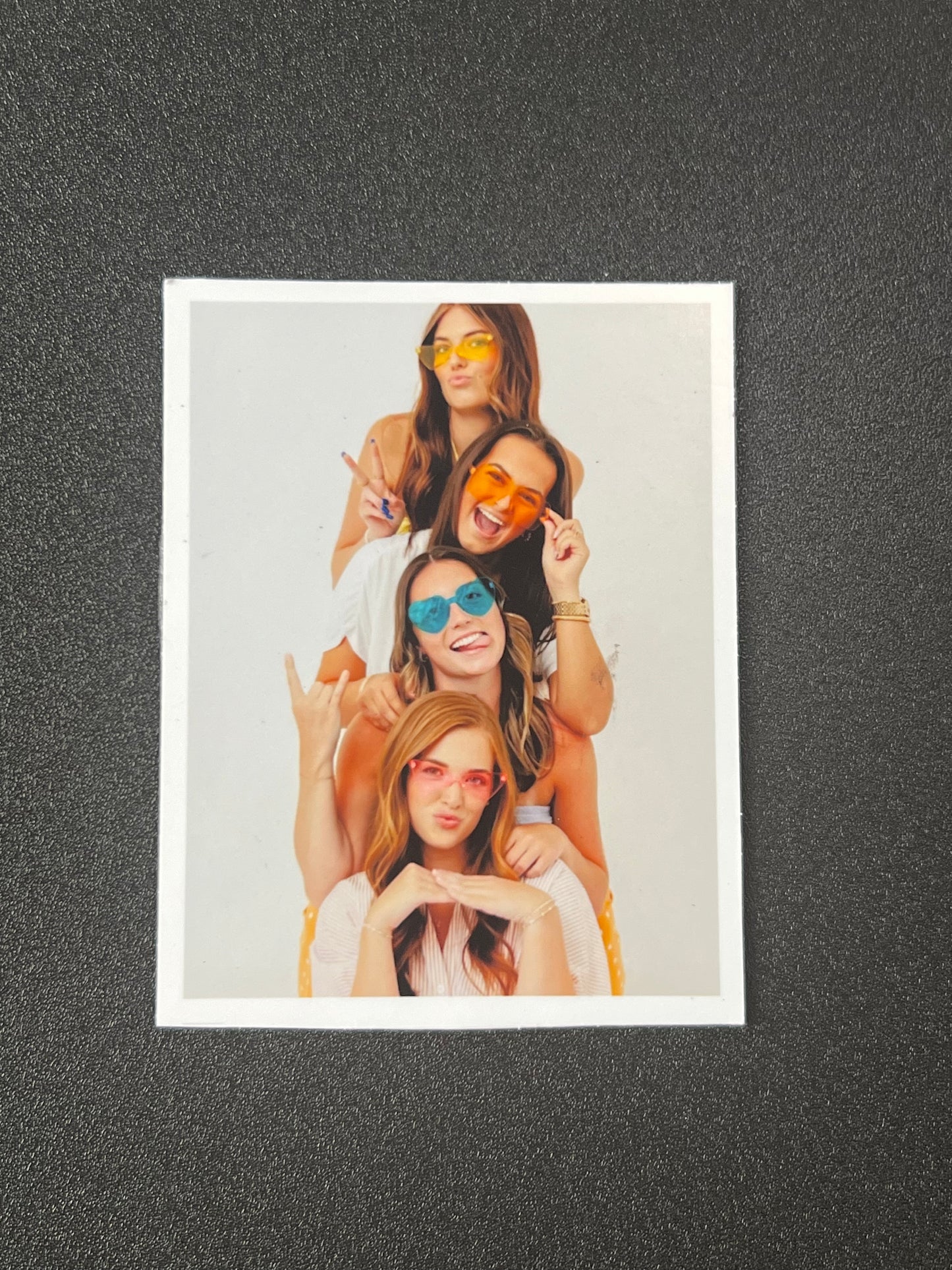 Three women wearing sunglasses on a light gray background