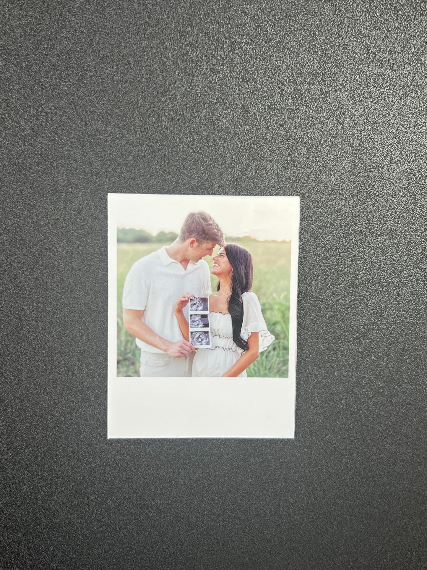 Couple holding a photo album with a gray background