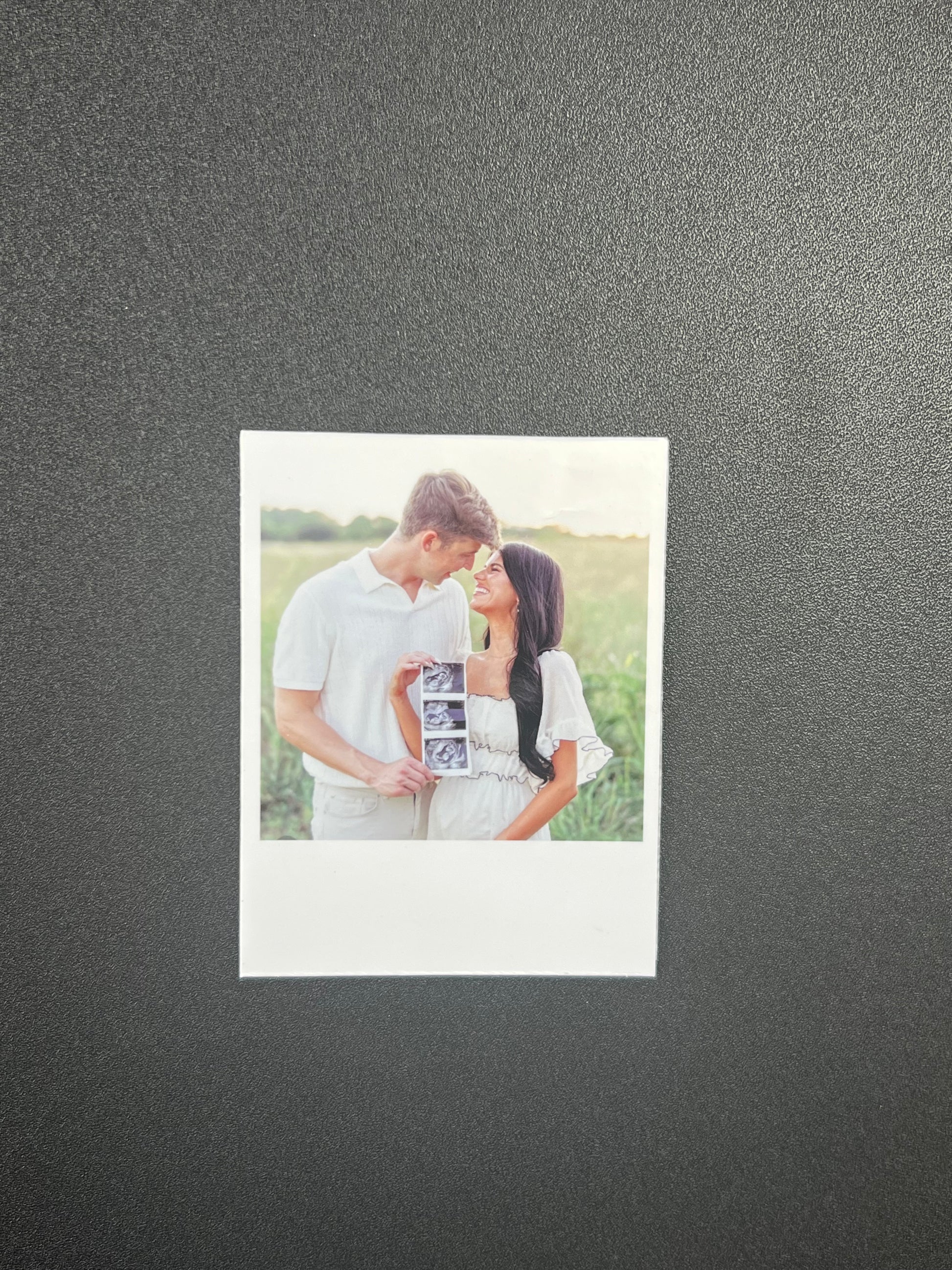 Couple holding a photo album with a gray background