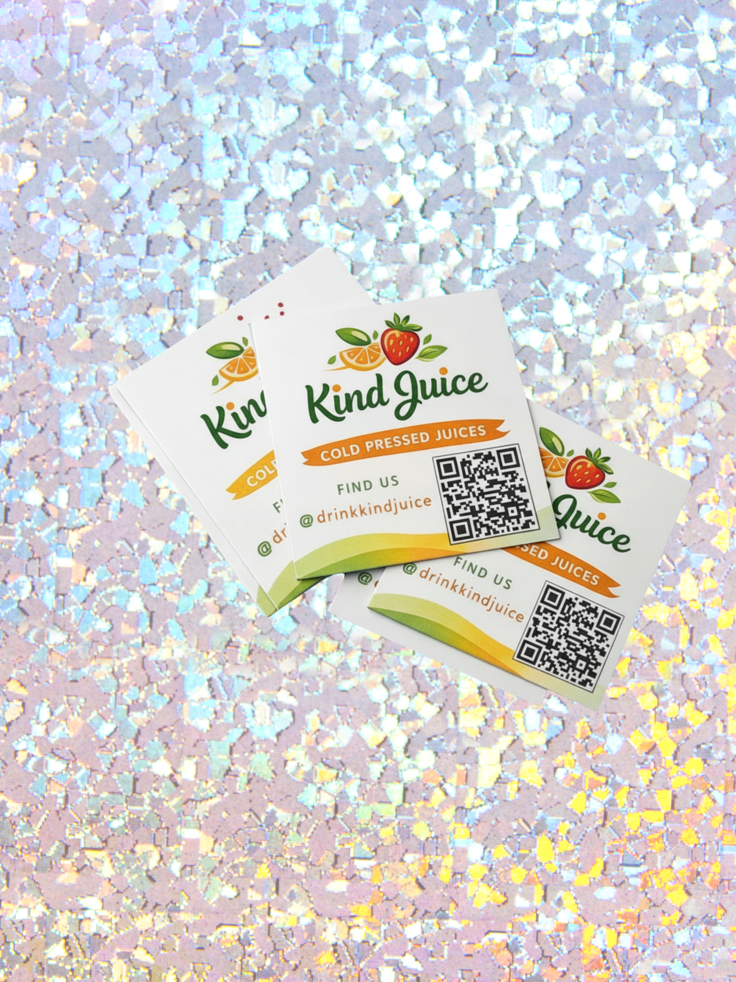 Two Kind Juice business cards on a glittery background