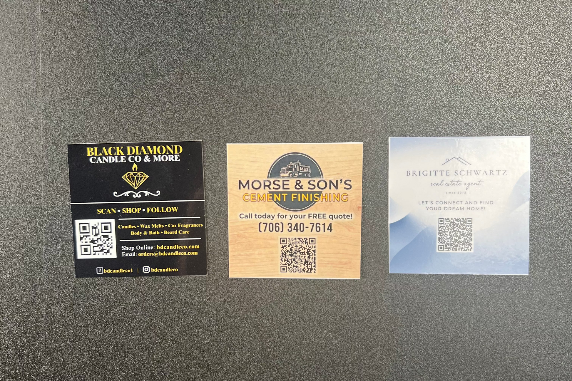 Three business branding cards on a gray surface
