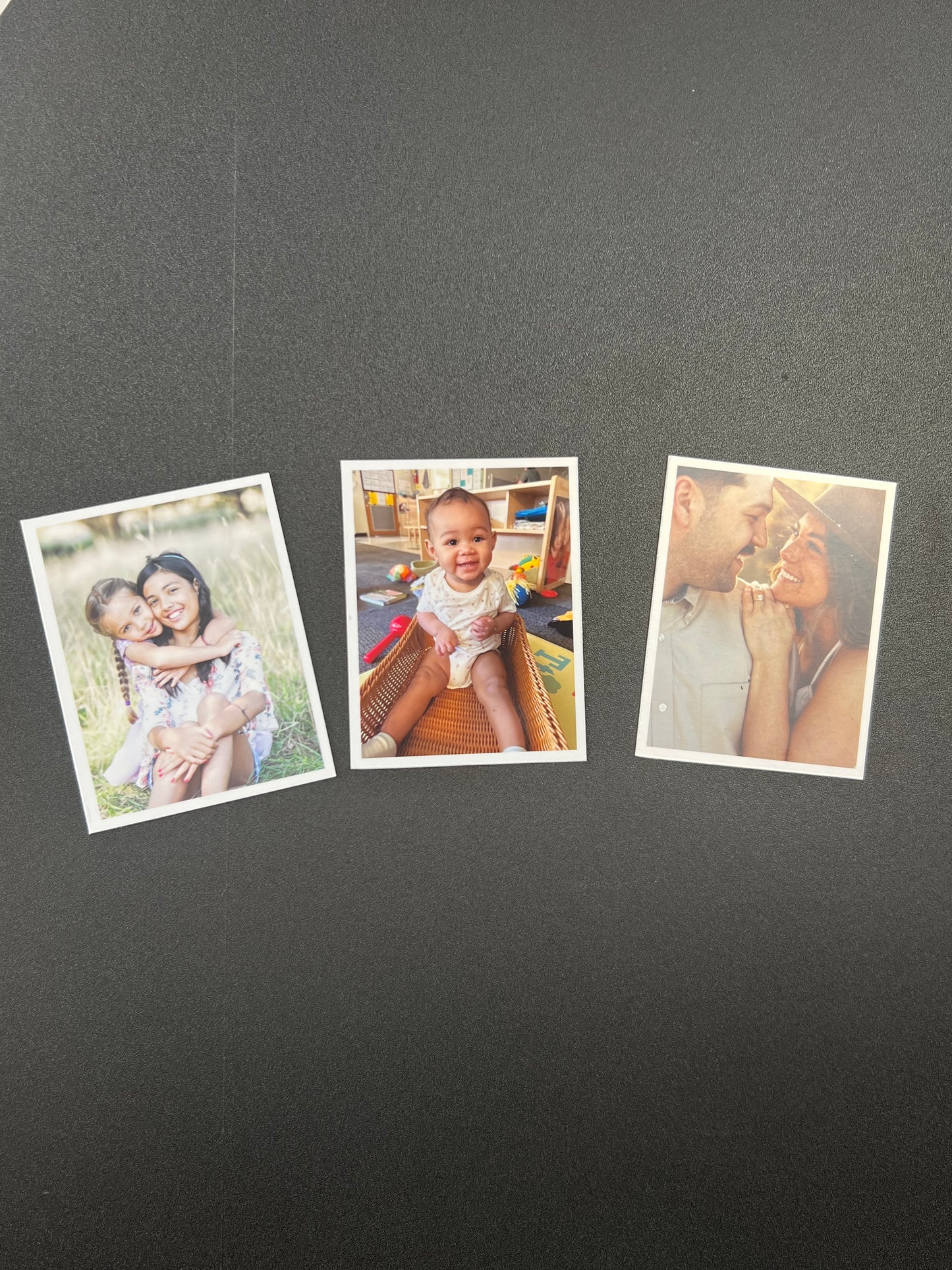 Three family photos on a dark gray surface